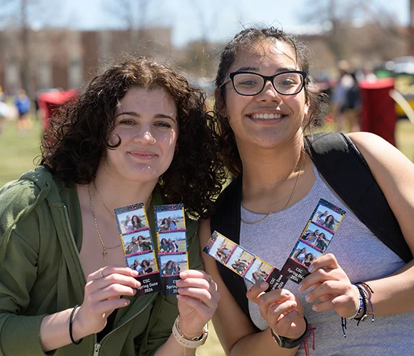 Two students showing photographs of themselves