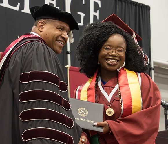 College president giving diploma to graduate