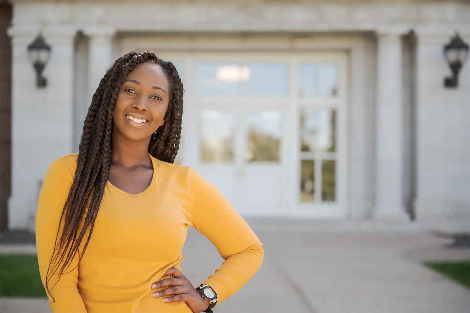 A student smiles in front of Old Admin