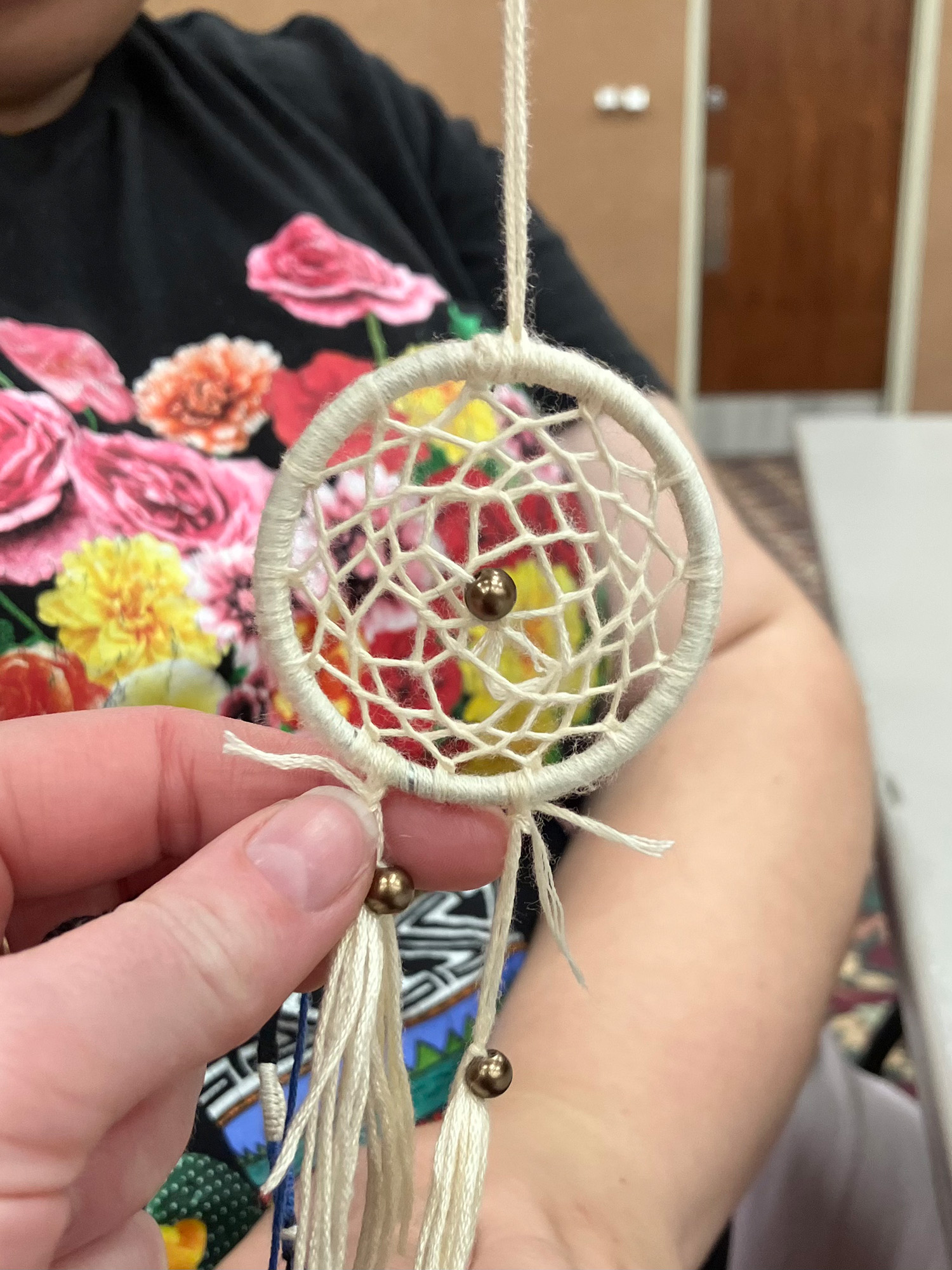 Student poises with a dream catcher on