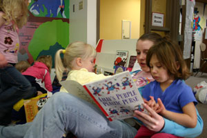 A student volunteer reads to children at the Child Development Center Laboratory