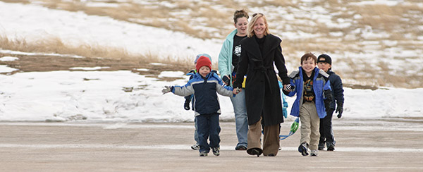 A student volunteer and a parent guide a group of children on a walk at the Child Development Center Laboratory