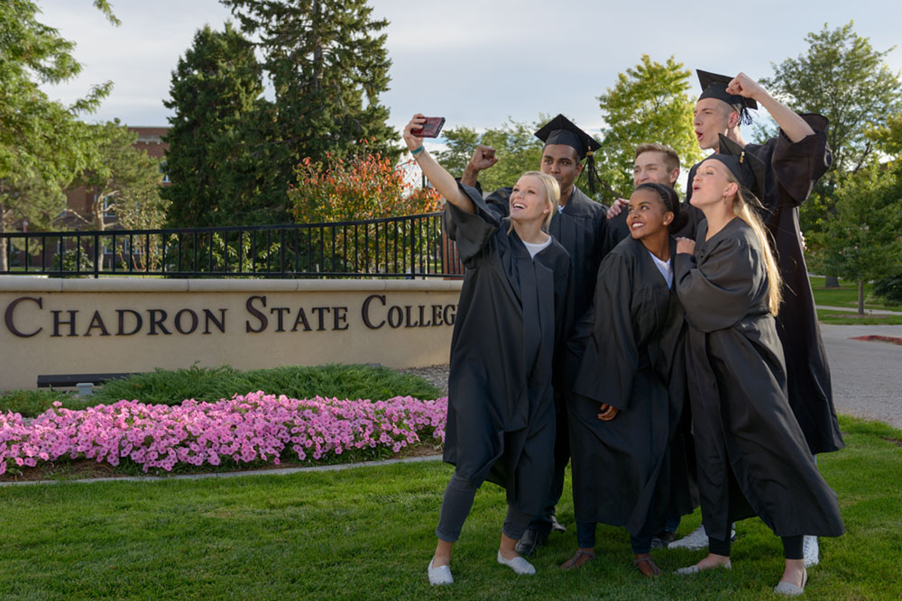 Students celebrate graduation at the college's main entrance