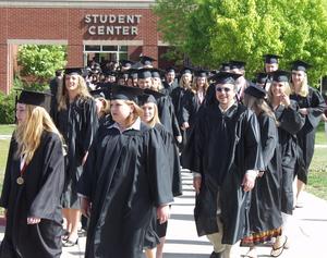 The graduates walk from the Student Center to Armstrong Gym before the ceremony.