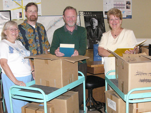 The Ashworths with Roger Kendrick, physics professor, and Lois Veath, dean of arts and sciences, and the books.