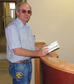 Rolland Sayer looks in a catalog for a special piece of material needed to complete the project.