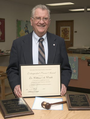 Dr. William Winkle displays the items he received from the Nebraska State Bandmasters Association and Nebraska Legislature.