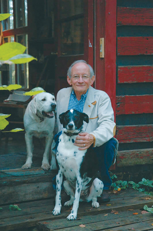 Ted Kooser poses with his two dogs.