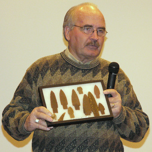 Dr. Larry Agenbroad holds a display of projectile points and butchering tools.