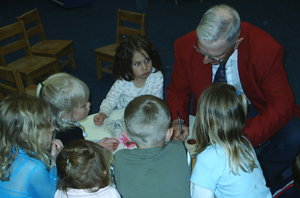 Chadron Mayor John Gamby is joined with children of the Child Development Center as he signs a proclamation.