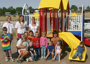 Children pose in front of the new playground equipment at the Child Development Center.