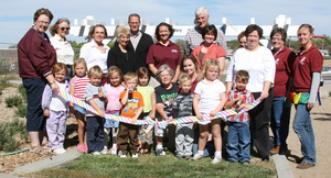 Children, staff, faculty members, volunteers, parents and advisory board members of the Child Development Center stand by as Berdine Maginnis Strashin of Crawford cuts the ribbon on the facility's new Happy Trail.