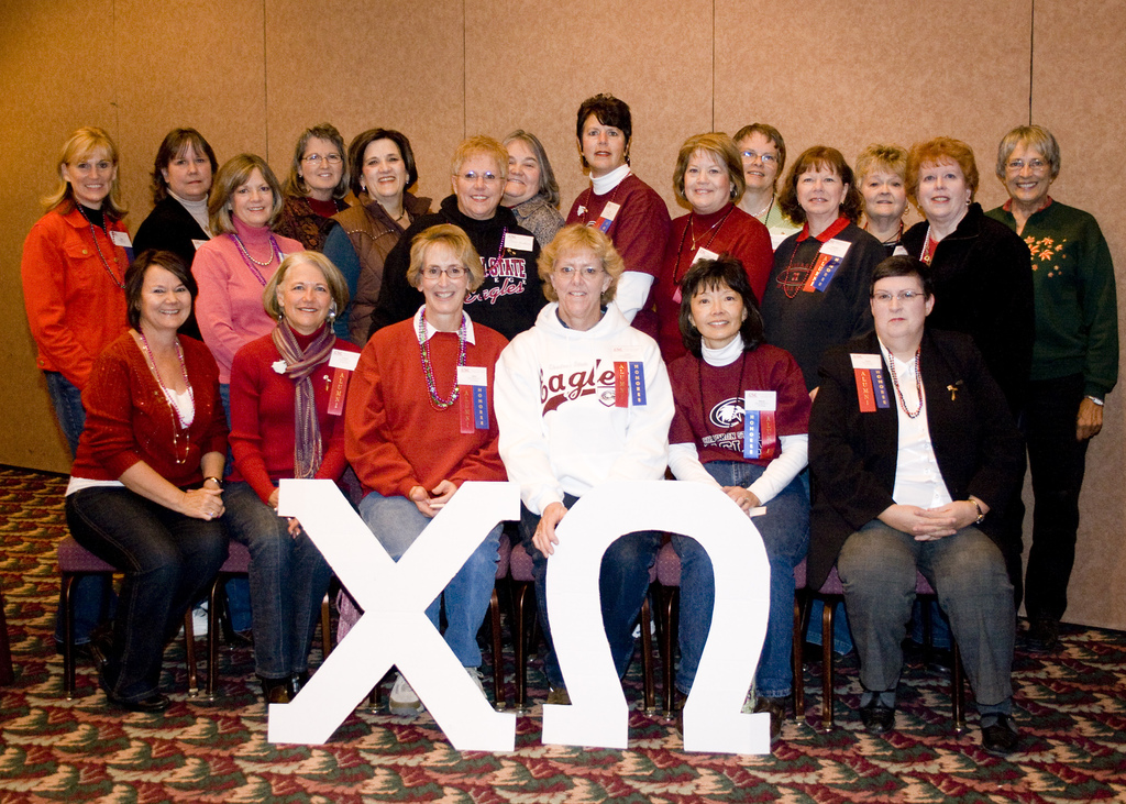 Women pose with sorority symbols