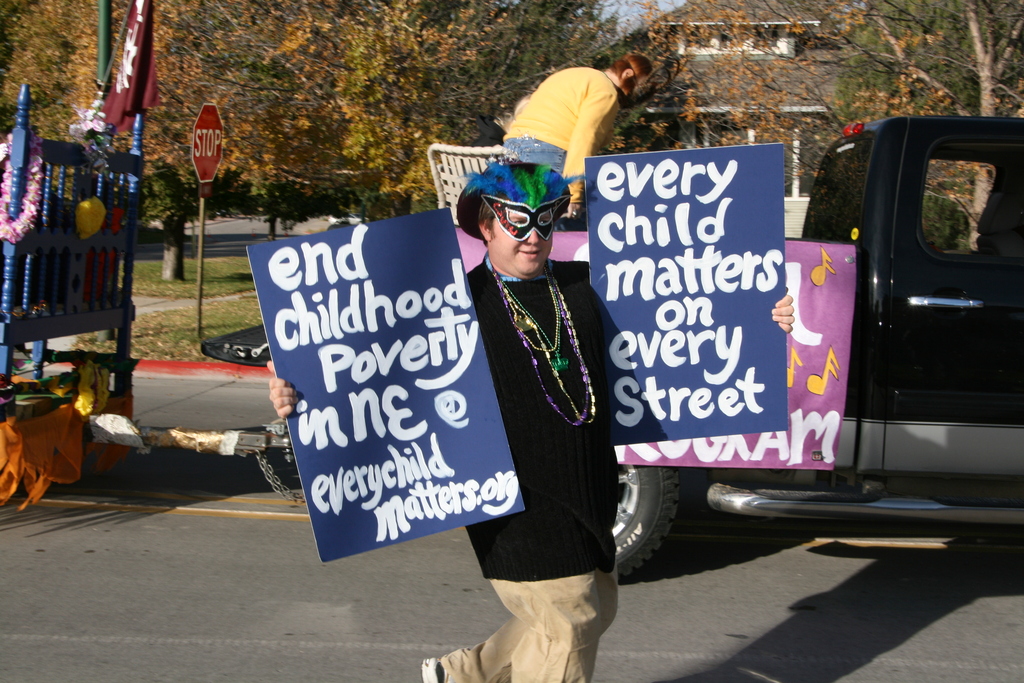 Student holds signs in homecoming parade