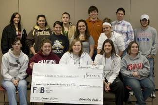 Students pose with a check