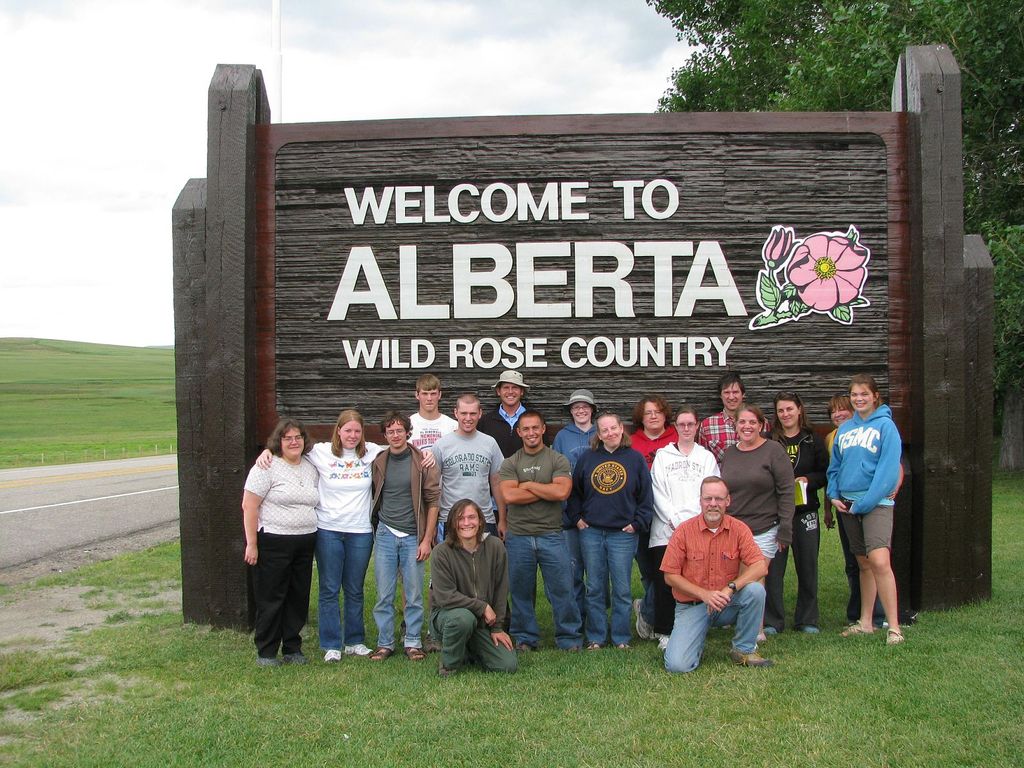 Chadron State College faculty and students pose in front of sign after entering into Alberta during their trip Aug. 9-20 to the Canadian Rockies.