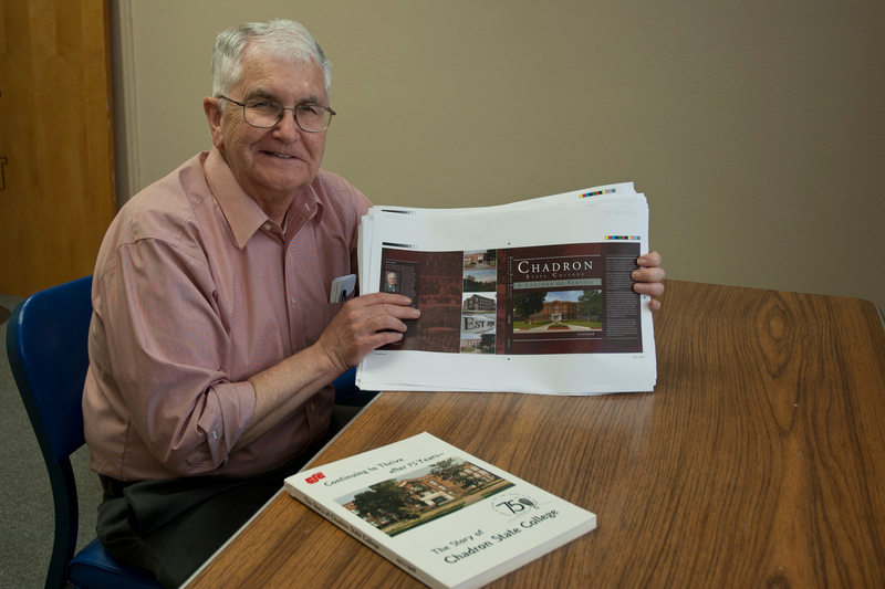 Con Marshall displays a proof copy of the centennial history book as a copy of the 75th anniversary book is shown in the foreground.