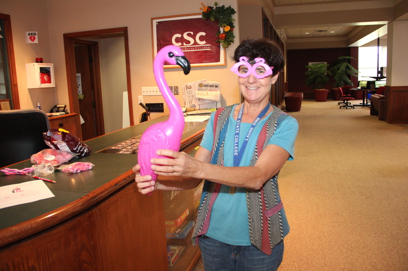 Laure Sinn, Chadron State College coordinator of student activities, takes hold of one of the birds that students will pursue during the Find the Flamingo contest.