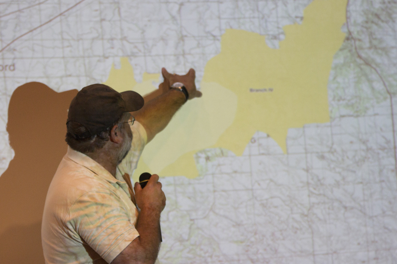 Fire behavior analyst Shane Del Grosso points to a map showing the burned area of the West Ash Creek Fire during a meeting in the Student Center on Saturday. (Photo by Justin Haag)