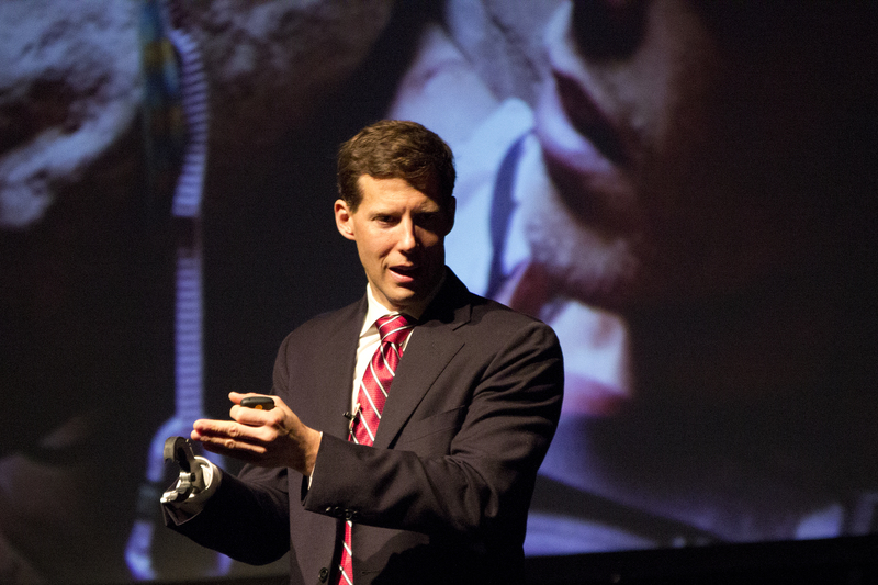 Aron Ralston speaks about his harrowing experience as a projection in the background shows his arm pinned beneath the boulder. (Photo by Justin Haag)