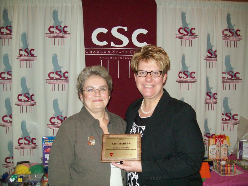 Dr. Kim Madsen, at left, receives the Distinguished Service to Children Award from Tracy Gordon of Lincoln, special projects coordinator for the Nebraska Association for the Education of Young Children.