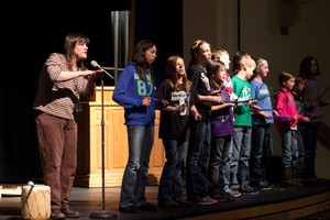 Chris Dickerson leads elementary and middle school students in song