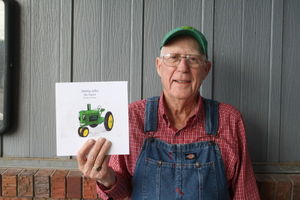 Ken Hinman holds a copy of 