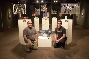 Two students pose with their art show display