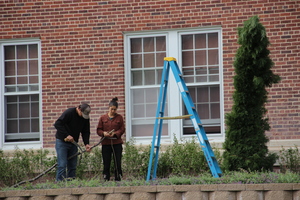 Two people trim a branch at Edna Work Hall