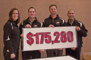 Several community members pose with fundraising poster