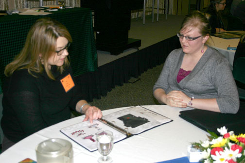 CSC art/graphic design student Macee Kellner looks on while her design portfolio is reviewed by an Omaha-area advertising/design professional at the 2014 American Advertising Federation Meet the Pros Conference.