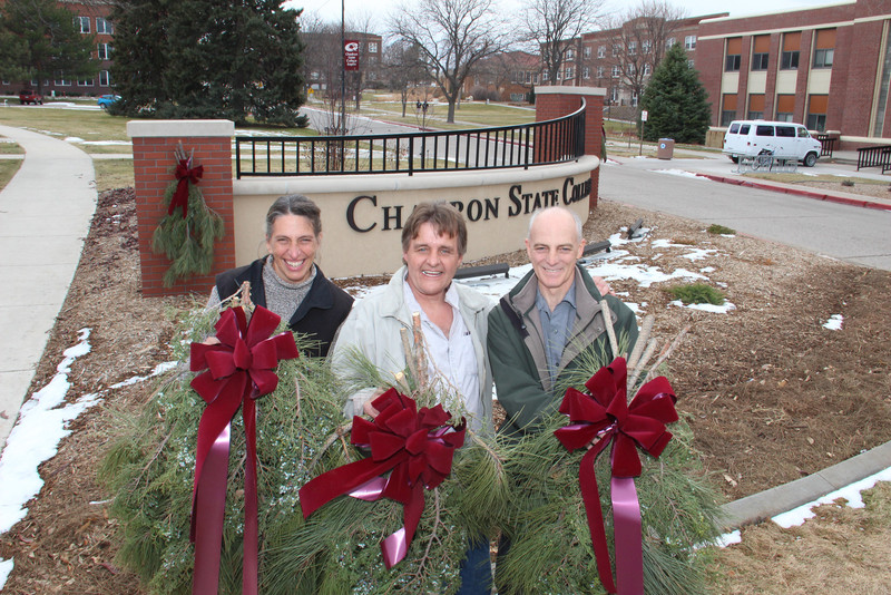 Jane Darnell, Roger Mays and Dewayne Gimeson display the greenery swags made by the Campus Arboretum Volunteers in December 2012. (Photo by Justin Haag)