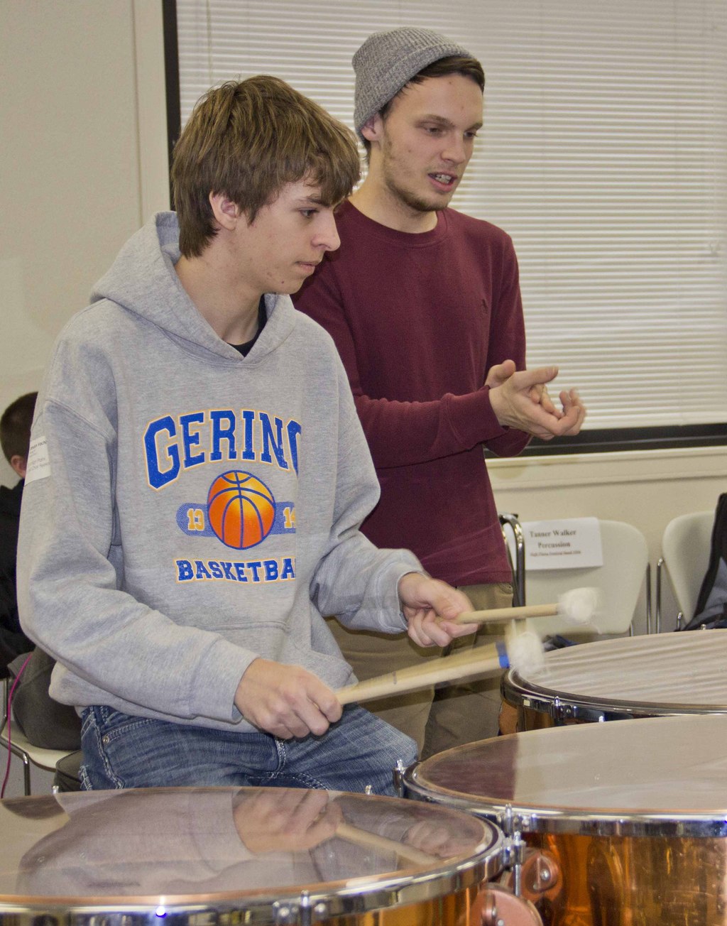 Chadron State College student Jack Royals, right, claps his hands in time to assist drummer Landon Vacha from Gering High School learn a new musical piece for the High Plains Band and Choir concert on campus Feb. 4