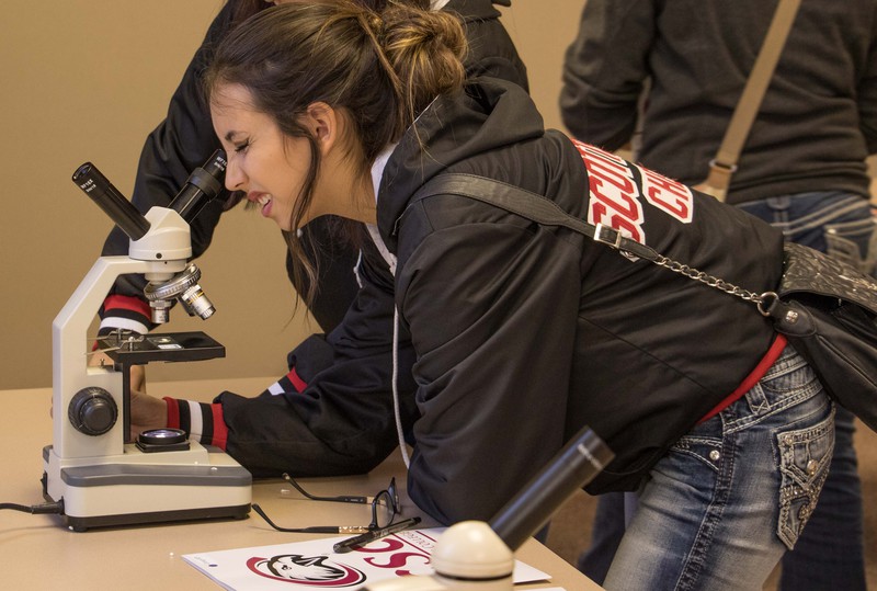 Hannah Balandran looks at slides using a microscope.