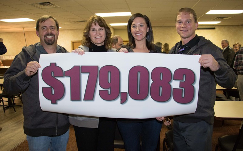 community co-chair Justin Haag, campus co-chairs Melissa Mitchell and Shaunda French and community co-chair Bobby Griese hold the fundraised amount.