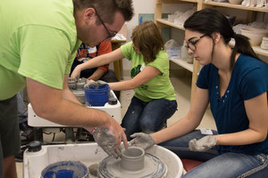 Cody Cooper helps Kassi Marx in ceramics class