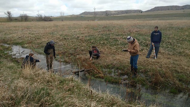 Students in the Science Skills and Success Learning Community measure the physical characteristics of the Chadron Creek stream bed.