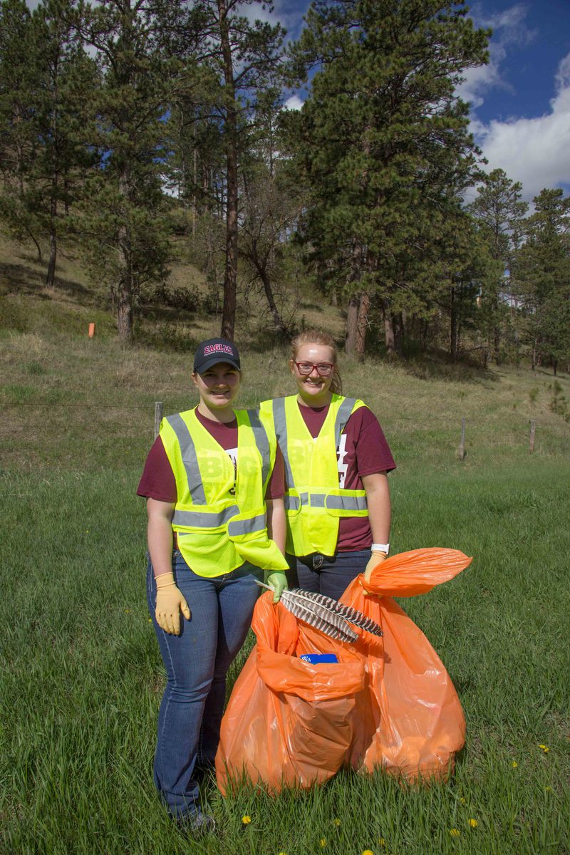 Chadron State College Art Guild members Kayla Anderson of Gothenburg, Neb., left, and Serena Brooks of Glenrock, Wyo., right, pose while cleaning up Highway 20 east of Chadron for The Big Event Saturday, April 22, 2017