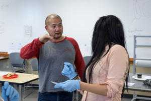 Dr. Jamie Wada speaks to student during forensics class