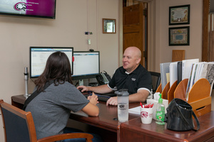 Chris Singpiel assists a student