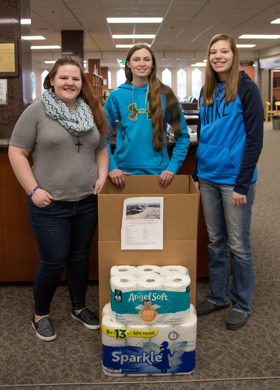 Chadron State College students who have helped with flood relief in eastern Nebraska and South Dakota pose with a donation box in the King Library April 3, 2019