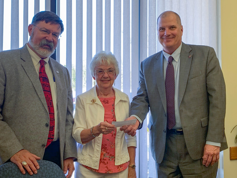 Kay Benson, center, poses for a photo with Chadron State College Dean of Professional Studies and Applied Sciences Jim Powell, left, and Chadron State College President Randy Rhine, right, May 1, 2019, in Hot Springs, S.D. Benson, a longtime friend of the late Mary 