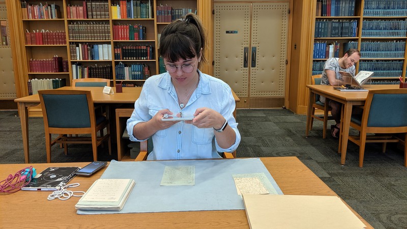 Chadron State College student Rachel Mitchell of Riverton, Wyoming, takes a photo of documents written by the late English essayist Vernon Lee during a May 2019 trip with Dr. Mary Clai Jones