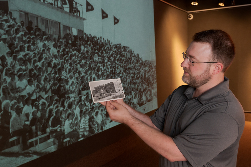 Daniel Binkard, digital graphic designer, holds a copy of a 1937 Old Admin photo.