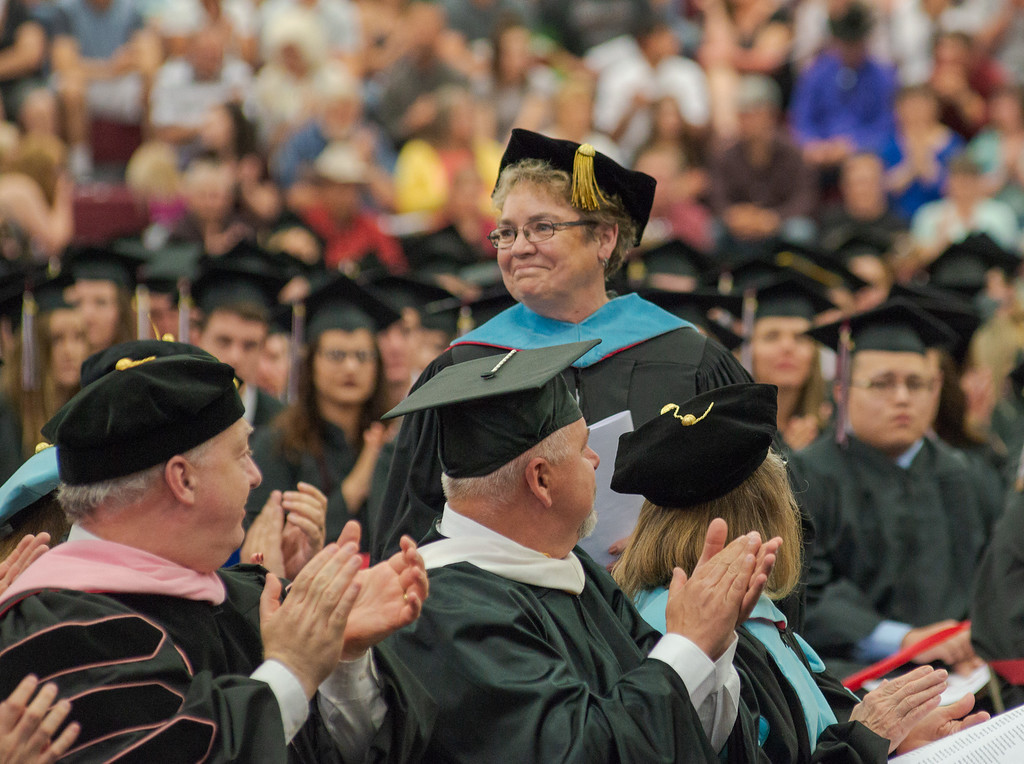 Dr. Kim Madsen, stands to be recognized as the recipient of a teaching award at CSC's undergraduate commencement.