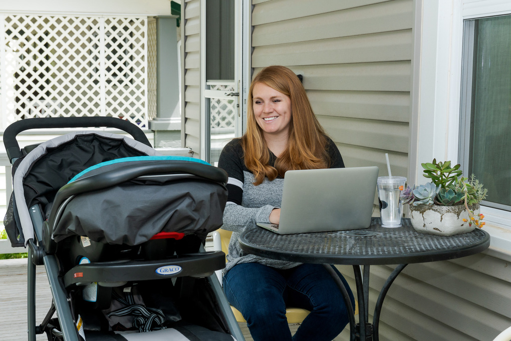 A student studies at home with her baby using CSC summer online courses.