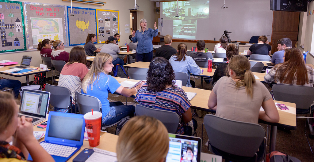 Dr. Karen Enos works with students on a project during a Teaching Elementary/Middle School Social Studies class.