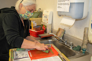 Chadron State College Art Professor Laura Bentz washes a screen after working on a collaborative print