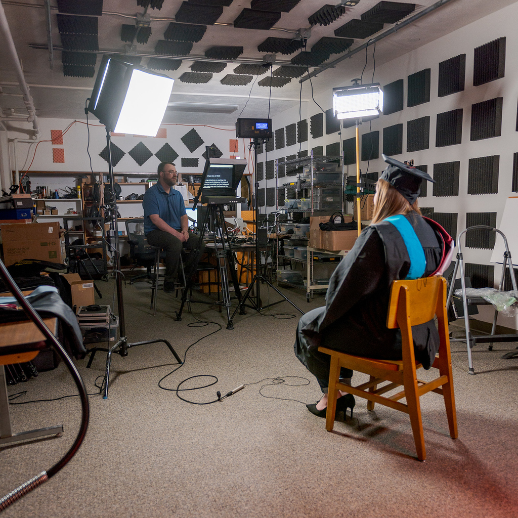 Digital Graphic Designer Daniel Binkard, background, records Kelsey Brummels in Crites Hall