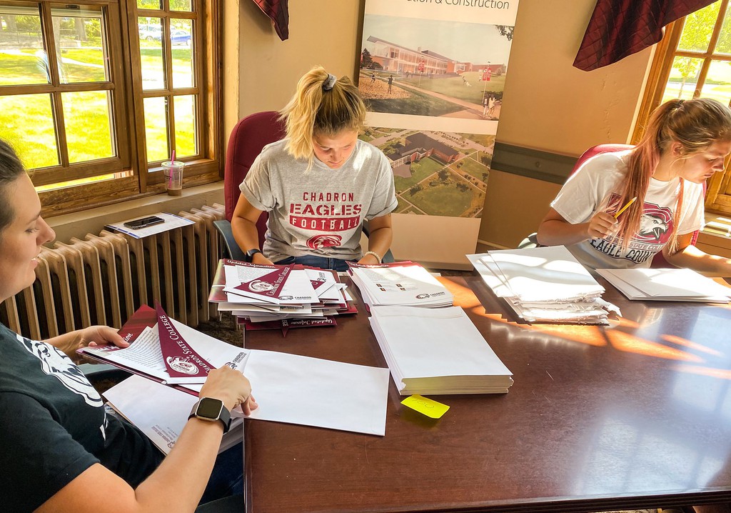 Chadron State College students employees prepare packets for incoming students.